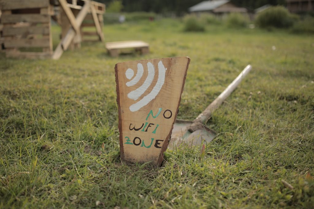 a wooden sign in the garden reads no wifi