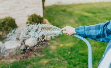 Water Supply in Your Garden a-person-is-spraying-water-from-a-hose