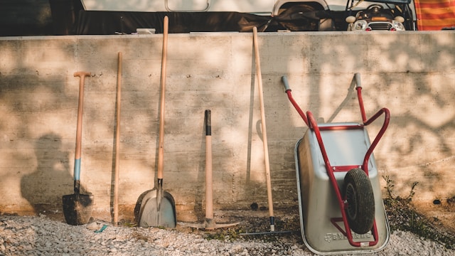 red-and-black-shovel-beside-brown-wooden-stick